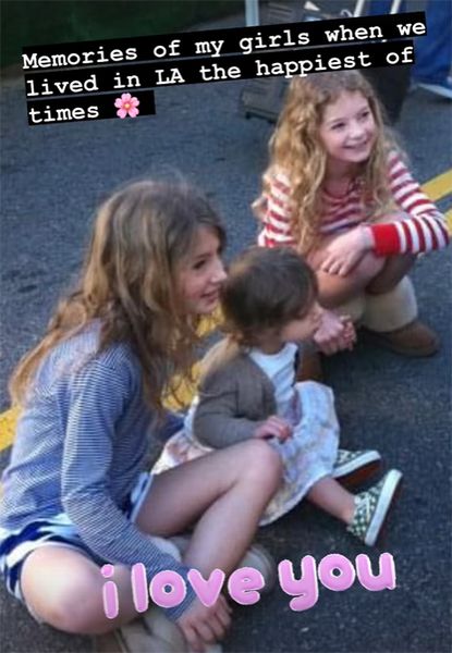 Three young girls sat on asphalt