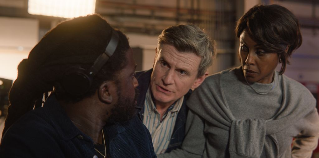 director talking to two people on set