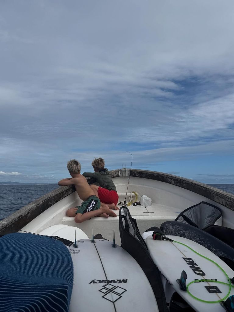 Tristan and Sasha Hemsworth looking out to sea sat on boat