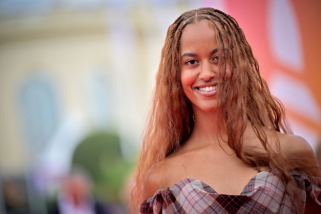 Malia Ann Obama wears her hair in tight braids at the roots, strapless dress, smiling 