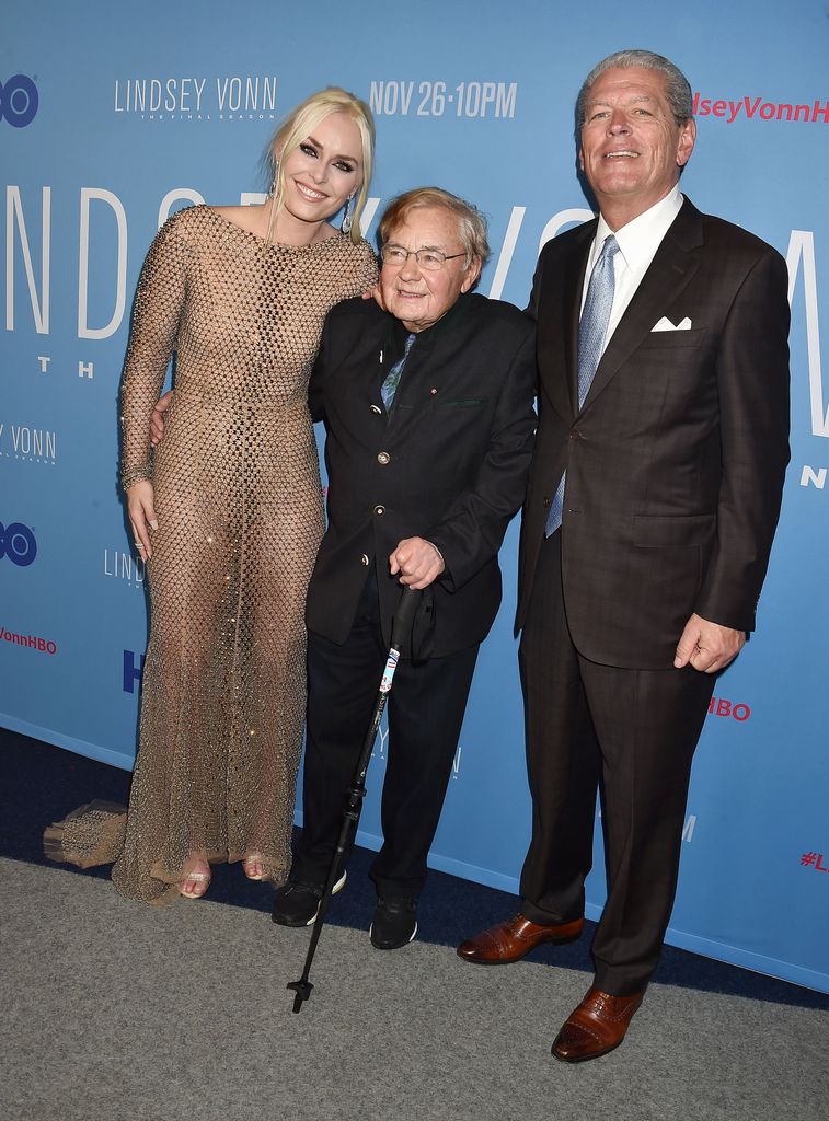 Lindsey Vonn en robe dorée posant avec Erich Sailer et Alan Kildow 