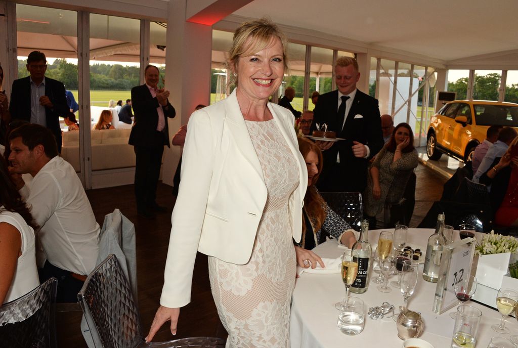 Carol Kirkwood in a white lace dress at a dinner party