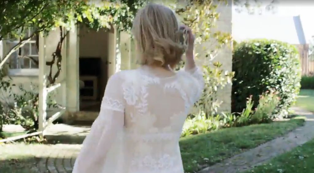 Nicole Kidman in a white dress walking towards a cottage