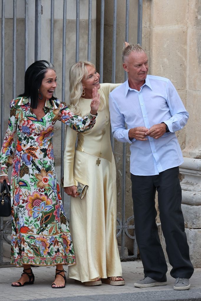 Trudie and sting with friend on street waving