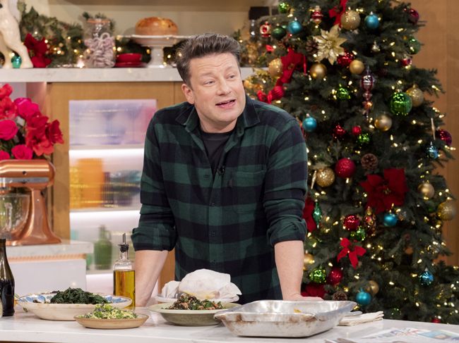 Jamie Oliver in a green check shirt cooking in a christmas setting