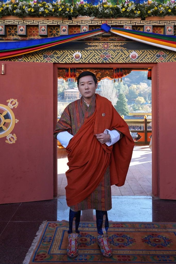 Prince Jigyel standing in front of an ornate doorway