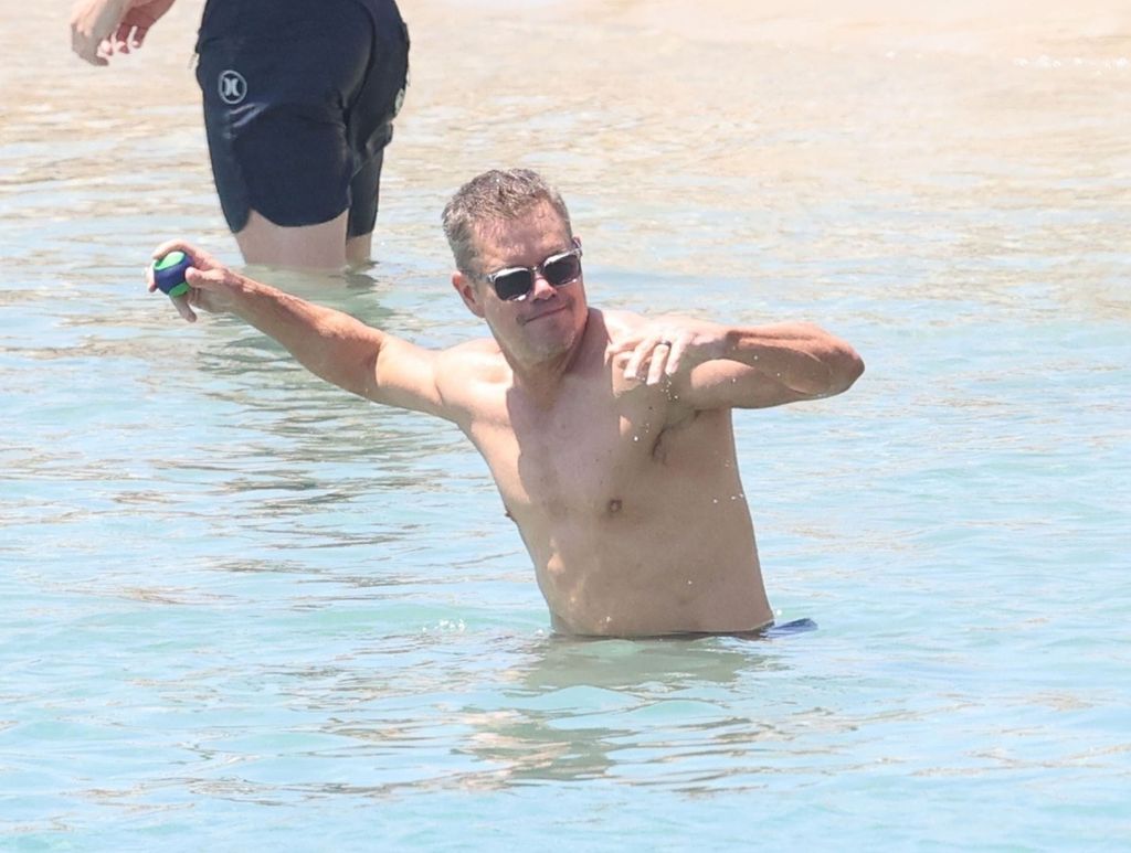 Matt Damon throws a ball as he stands in the Greek ocean 