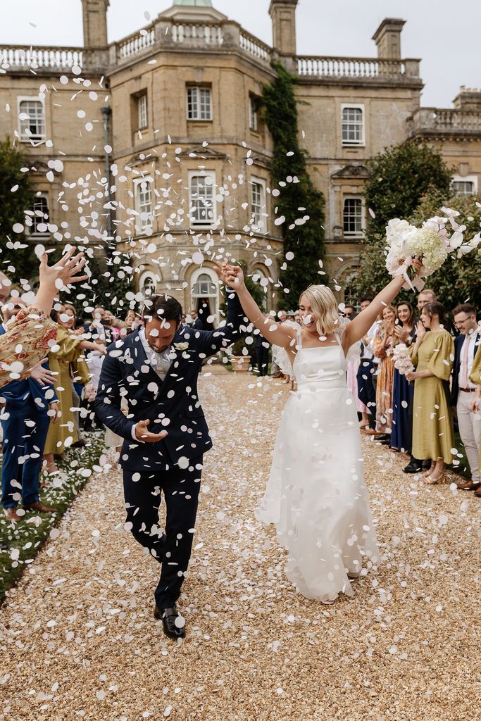 Newlywed couple being showered with confetti outside their wedding venue