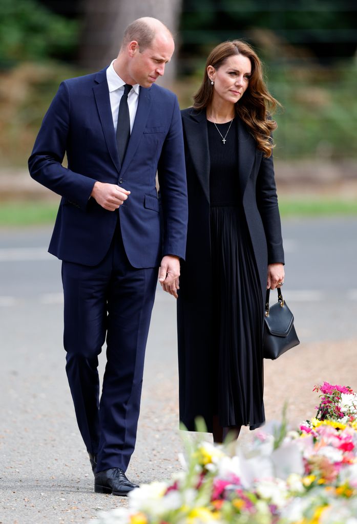 Prince William, Prince of Wales and Catherine, Princess of Wales view floral tributes left at the entrance to Sandringham House