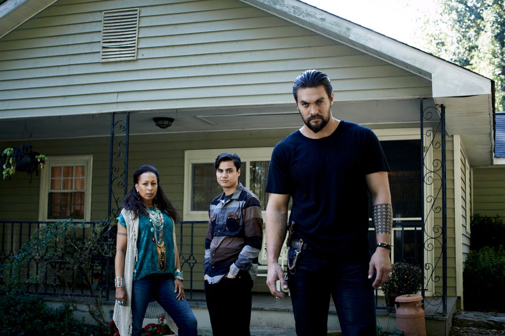 three people standing outside house 