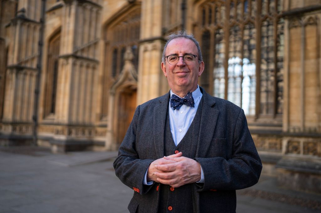 Rev. Richard Coles in a suit outside an ornate building