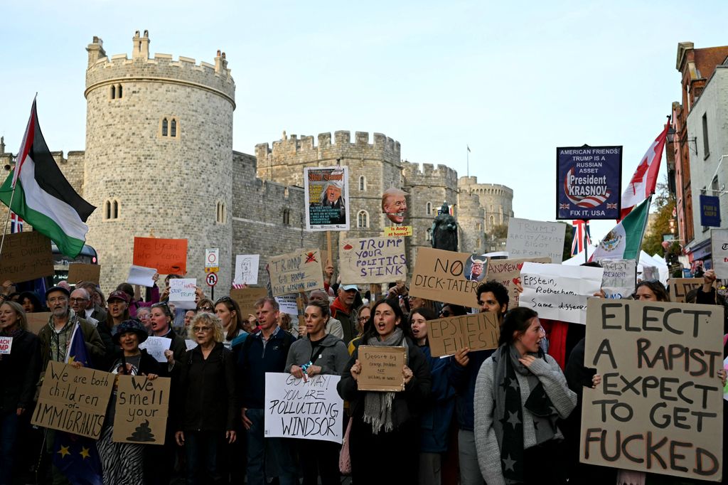 Demonstrators hold placards during a protest against the forthcoming State Visit of US President Donald Trump, outside Windsor Castle in Windsor on September 16, 2025. US President Donald Trump is set arrive in the UK late September 16, 2025 for a second State Visit with his wife Melania, made at the invitation of King Charles III