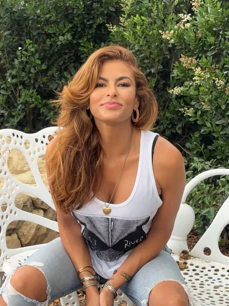 Eva Mendes pose dans sa cour portant un gilet avec l'affiche du film "River Lost," partagé sur Instagram