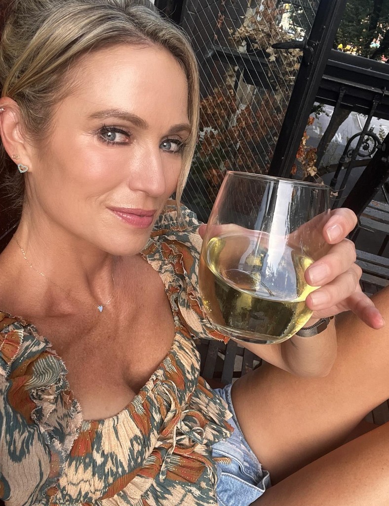 Photo shared by TJ Holmes on Instagram in honor of Amy Robach's  birthday of her with a white wine glass