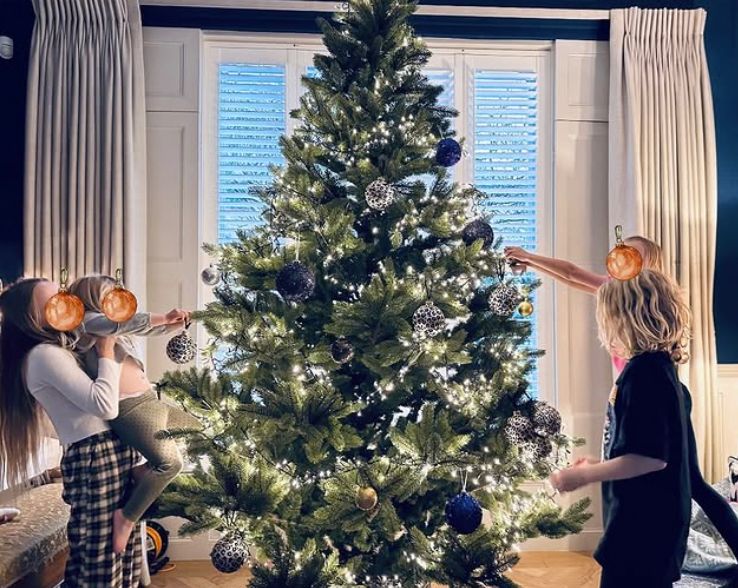 Four children decorating a Christmas tree