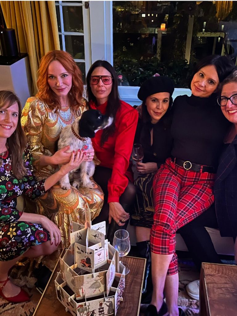 christina hendricks wearing a metallic gown with her friends while celebrating the christmas season