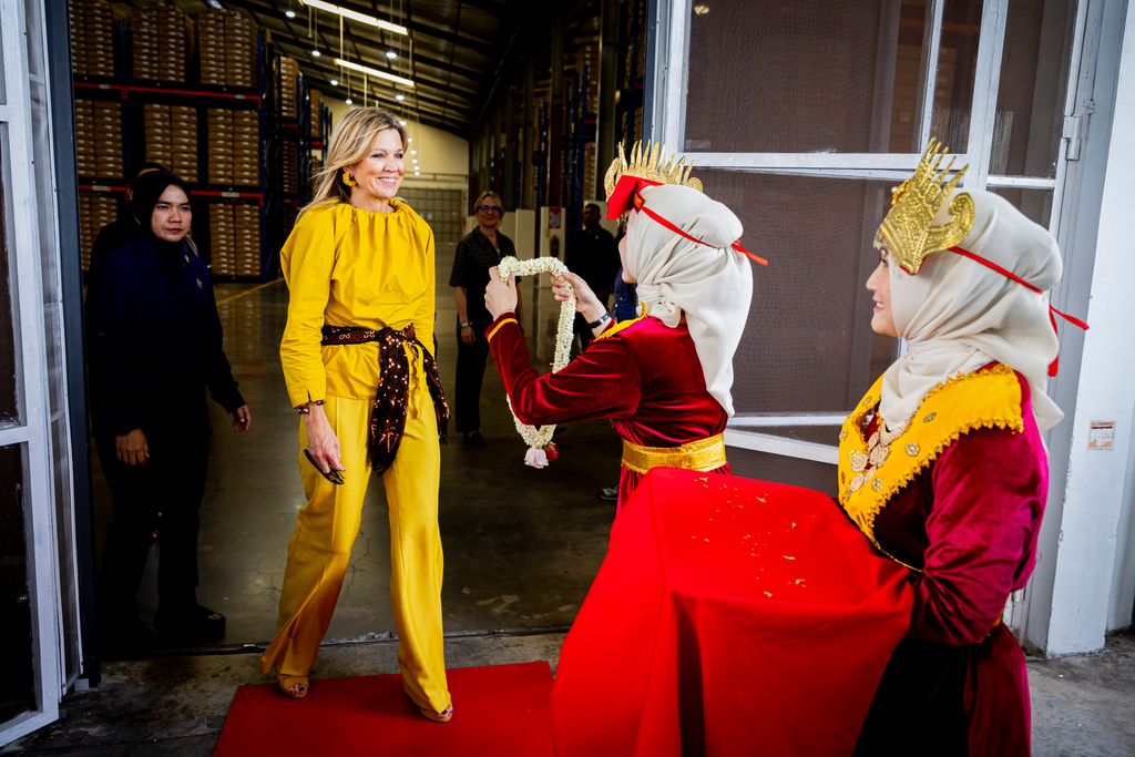 Queen Maxima being greeted in mustard yellow co-ord