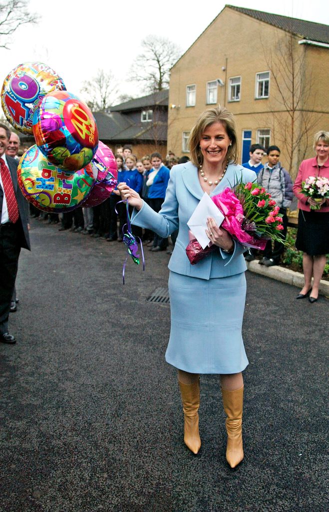 Sophie with balloons and flowers given by pupils celebrating her 40th birthday