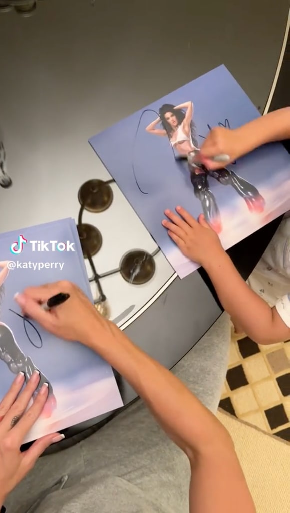 Daisy Dove Bloom and mom Katy Perry autograph copies of the latter's album 143 together, shared on TikTok