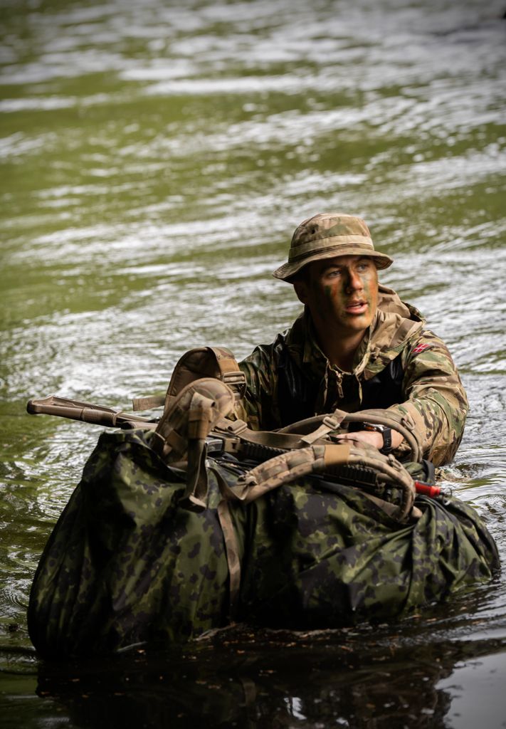 Crown Prince Christian wading through river during military training