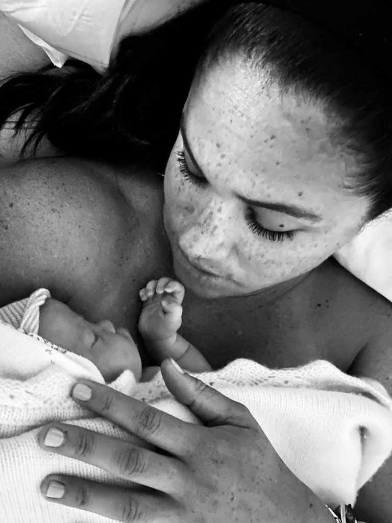 Black and white photo of Meghan holding newborn Lilibet