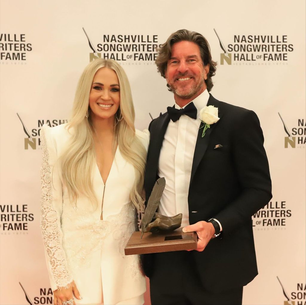 photo of carrie underwood and brett james in suits