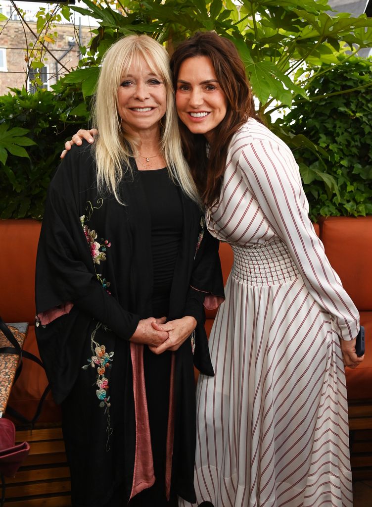 Jo Wood and Angela Richardson pose together, one in a floral embroidered kimono and the other in a striped smocked waist dress at RHS Chelsea Flower Show 2025