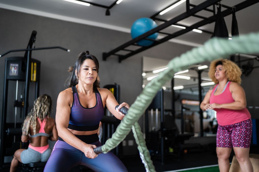 woman working out with battle ropes at the gym
