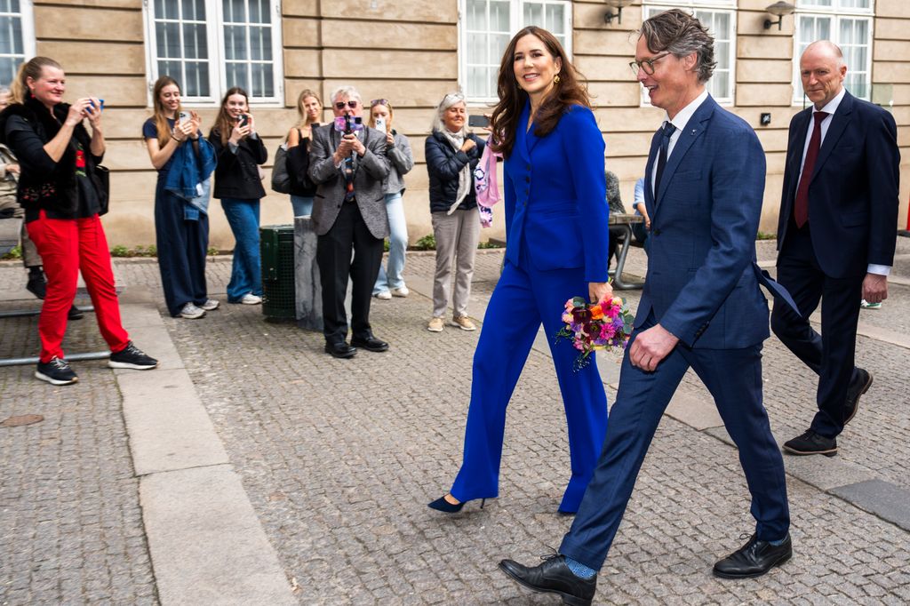 Queen Mary walking in a blue suit