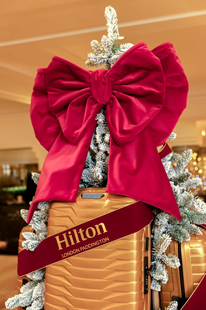 a christmas tree in London with a suitcase on it 