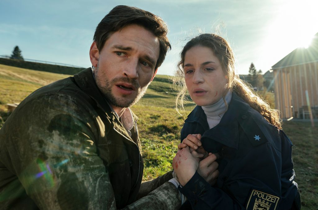 man and woman holding hands in field