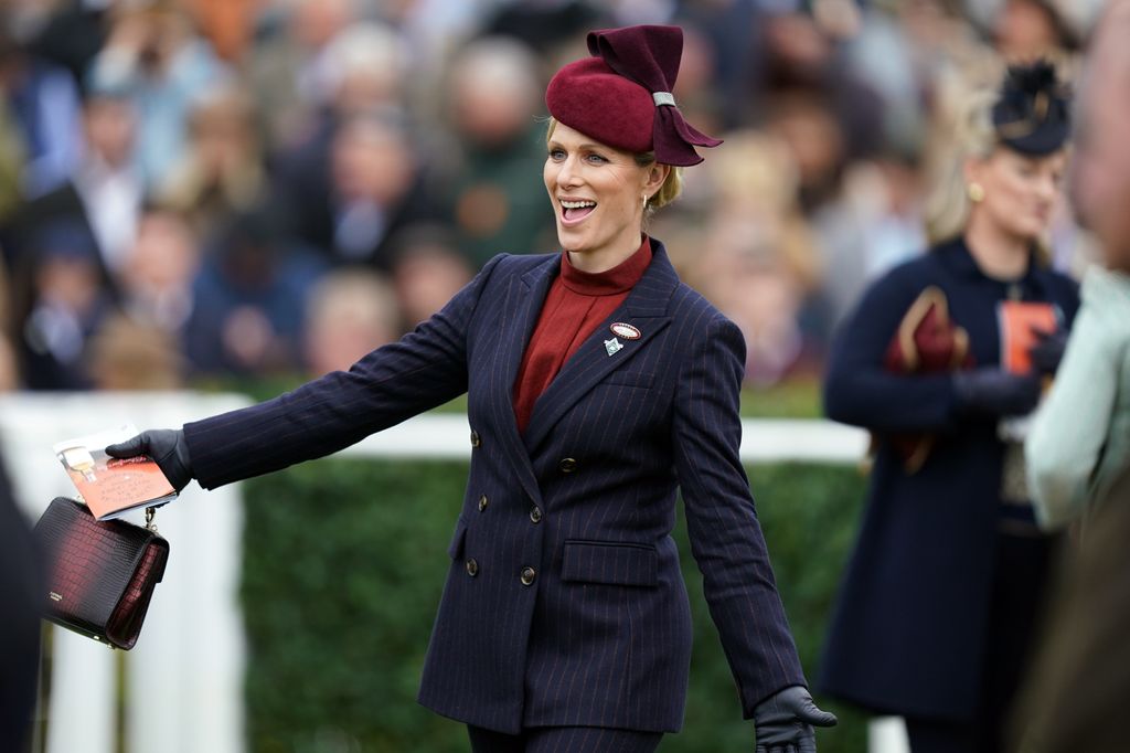 Zara Tindall with arms out smiling at race course
