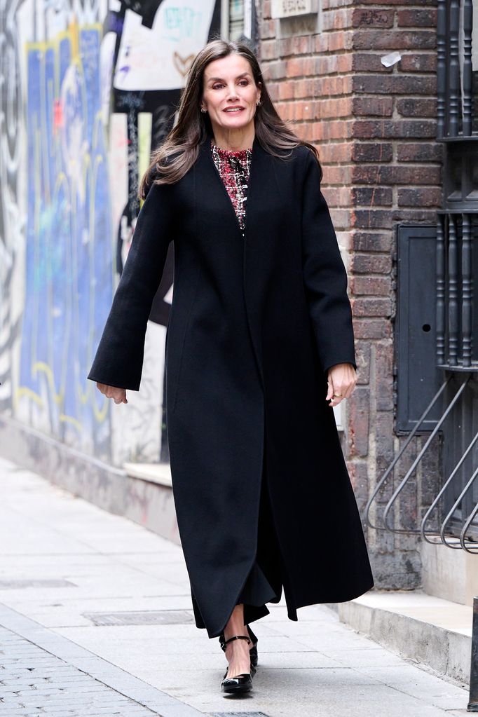 Queen Letizia in a longline black coat on street