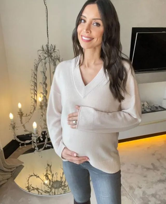 Christine Lampard in her living room holding baby bump