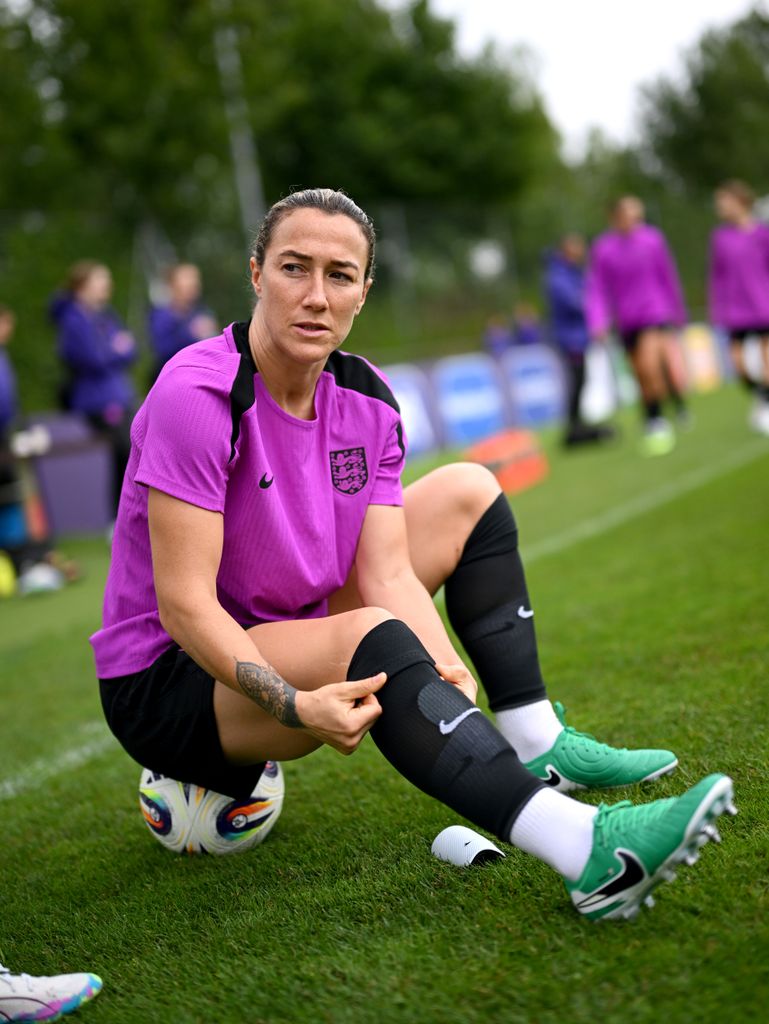 Lucy Bronze sitting on a football at a training camp