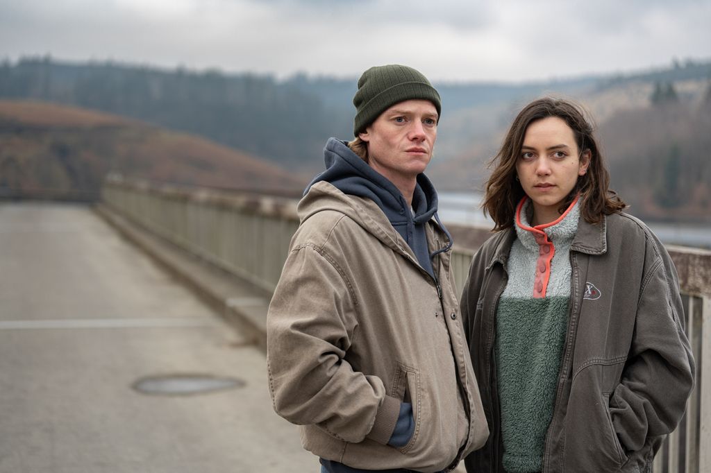 young man and women standing on bridge