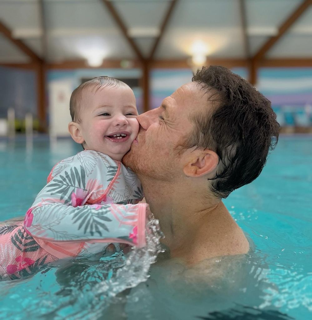 father swimming with baby daughter 