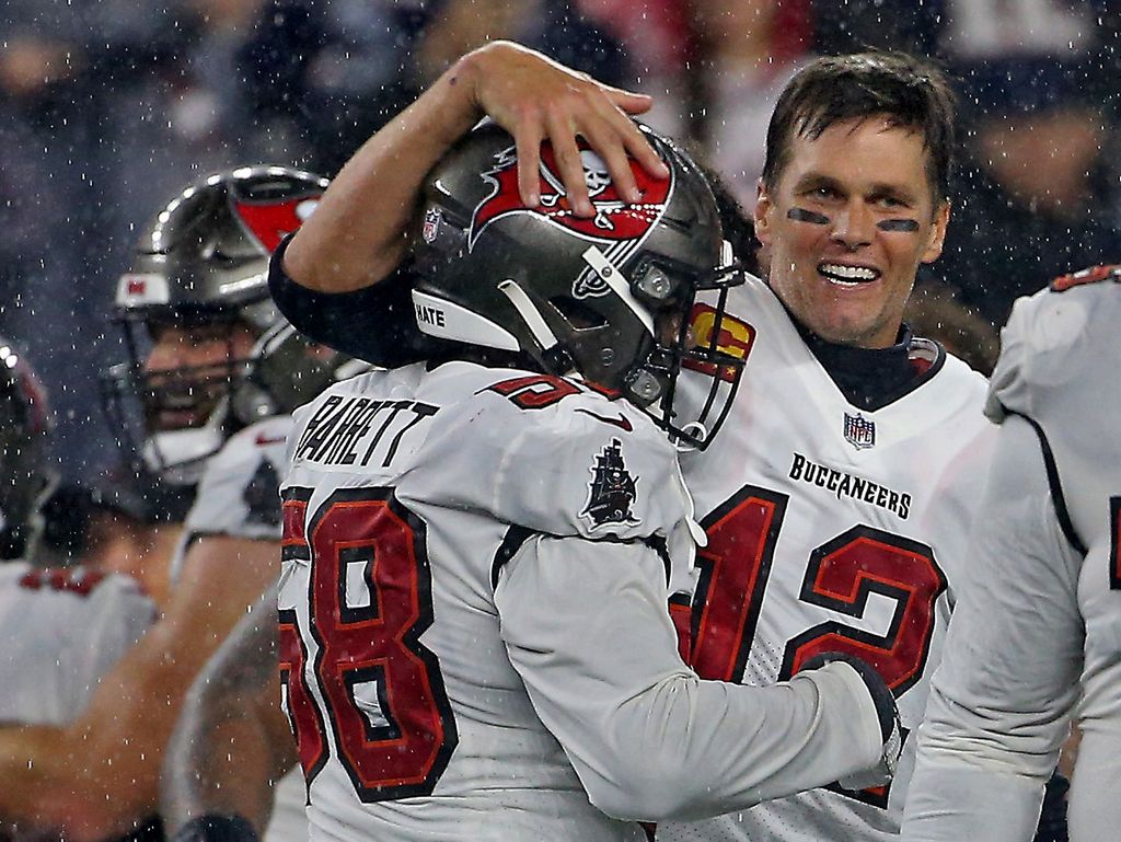 Tom Brady #12 of the Tampa Bay Buccaneers celebrates their win with Shaquil Barrett #58 on the sidelines after the Patriots missed a field goal during the forth quarter of the NFL game at Gillette Stadium on October 3, 2021 in Foxboro, Massachusetts