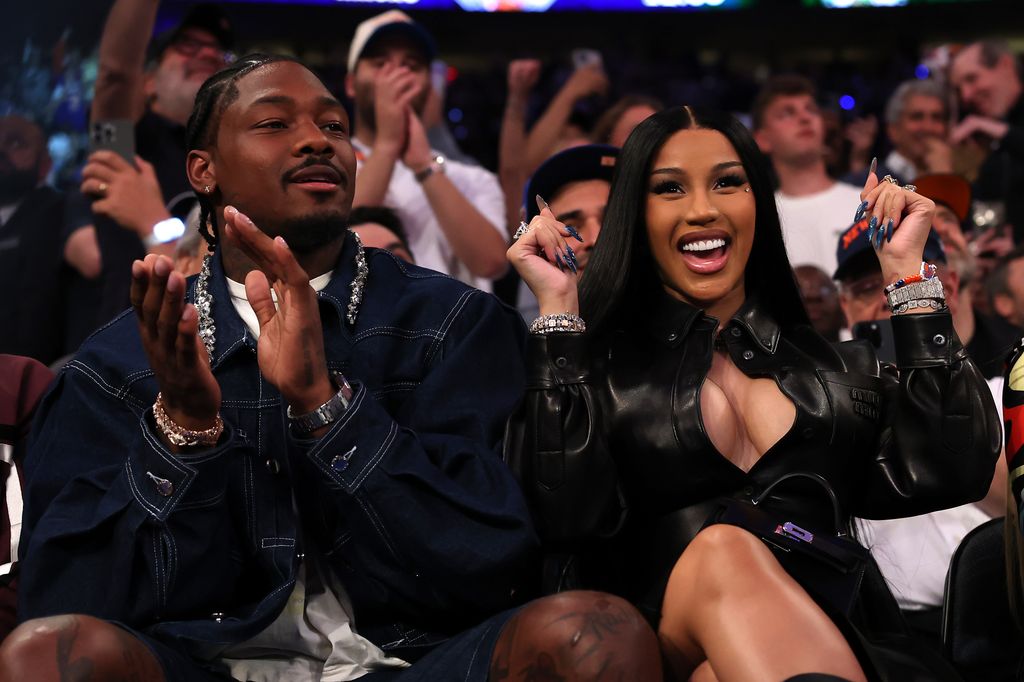 photo of stefon diggs and cardi b sitting courtside cheering at nba game
