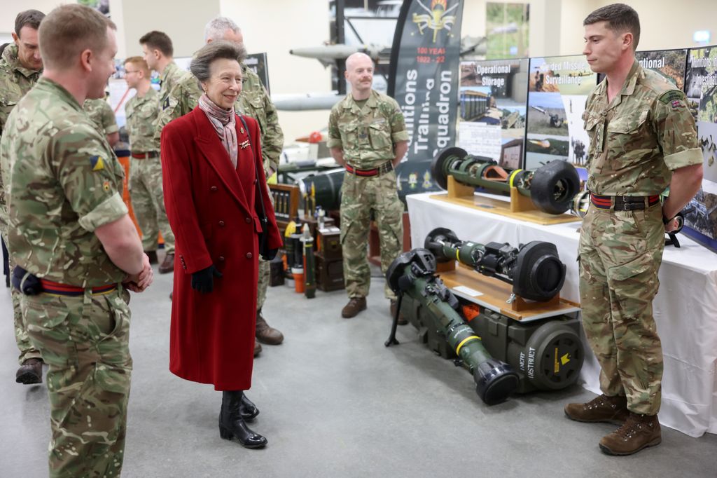 Princesa Anne olhando armas com militares