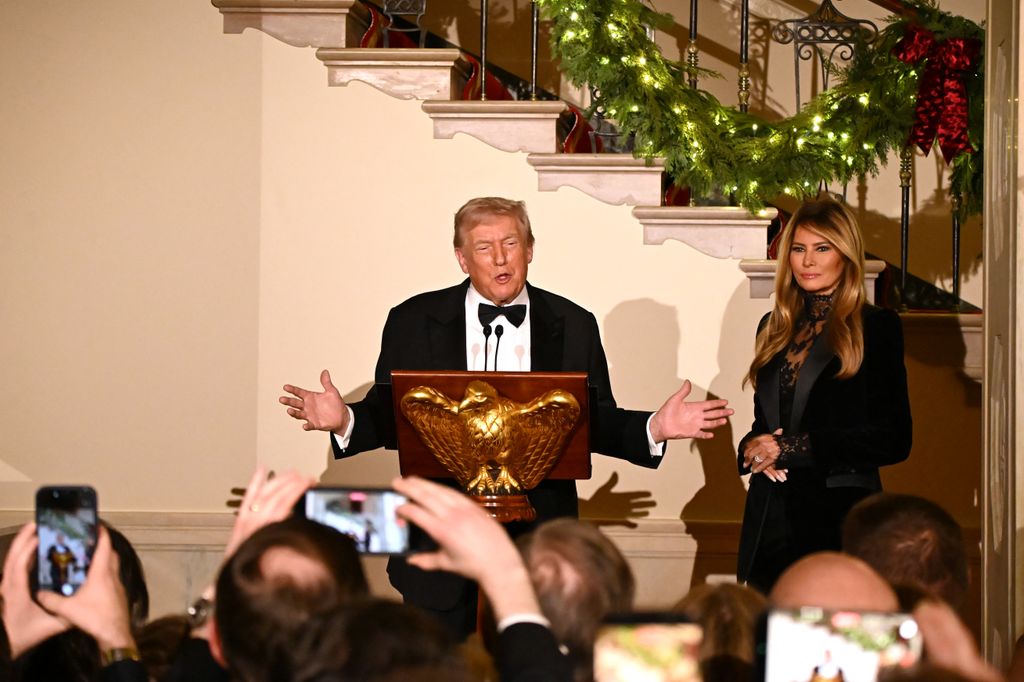 US President Donald Trump in tuxedo, accompanied by First Lady Melania Trump in sheer black blouse and blazer, delivers remarks during the Congressional Ball in the Grand Foyer of the White House