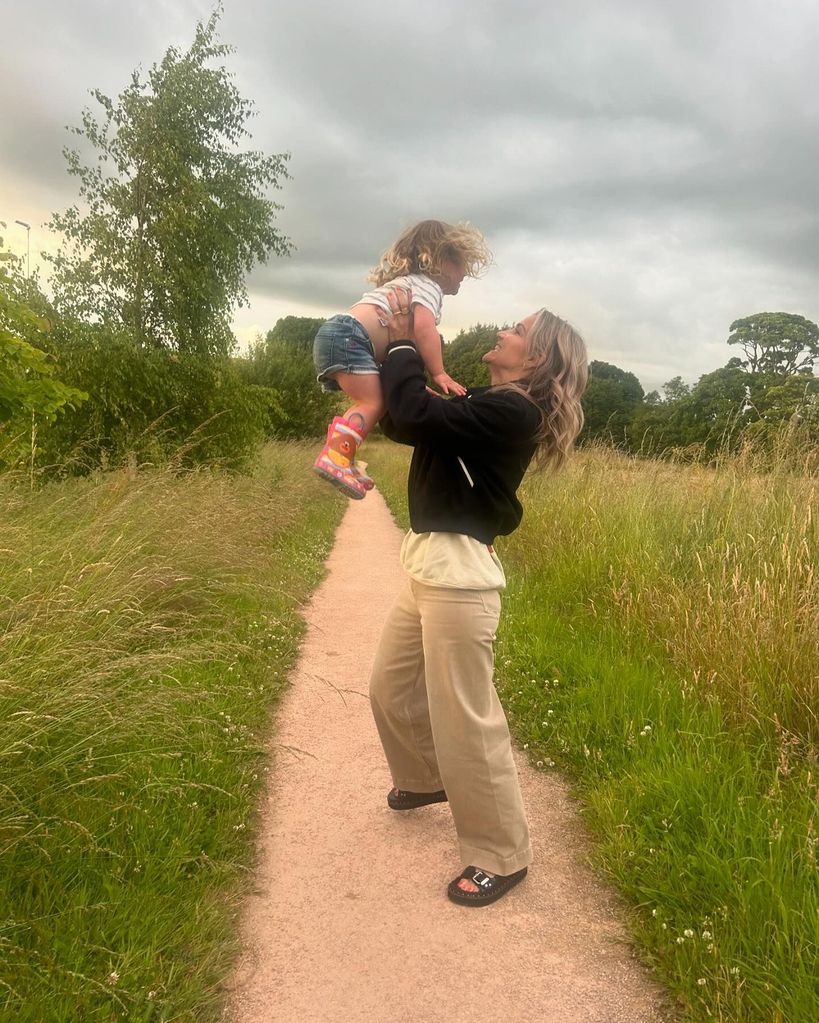 mother holding daughter in air