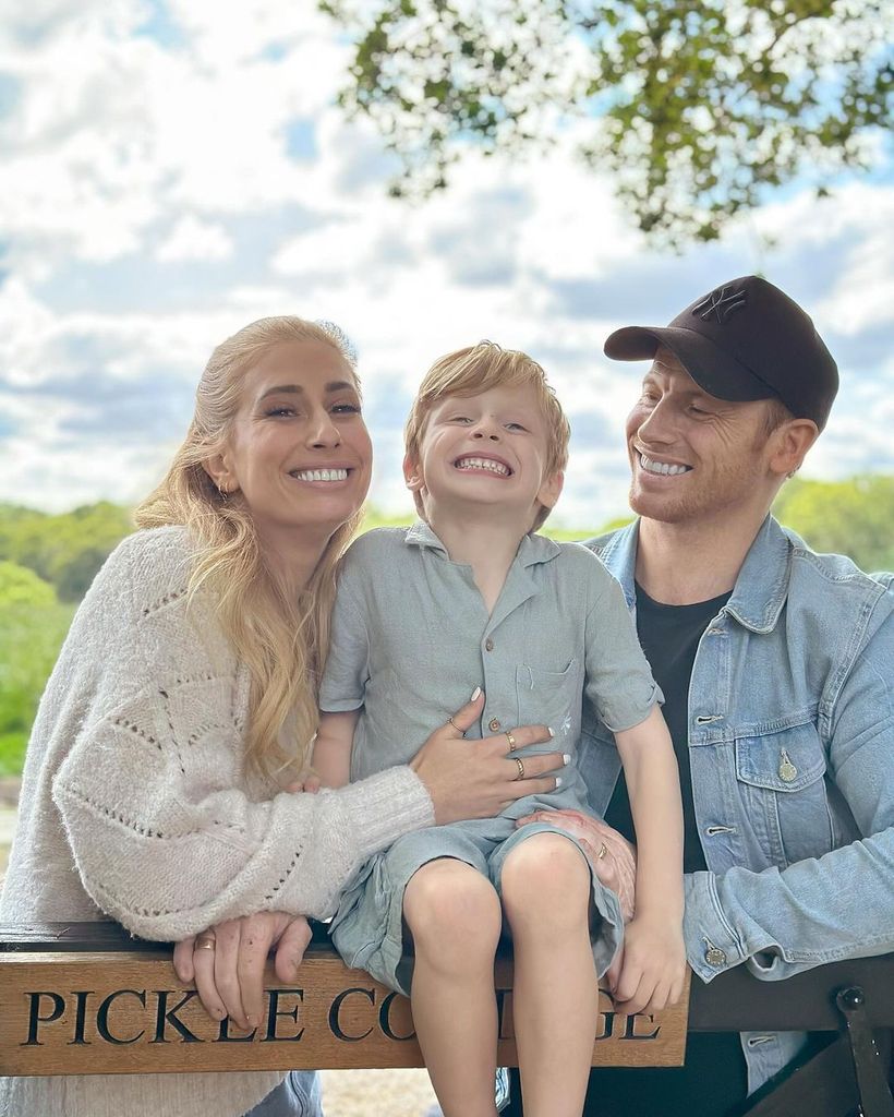 Stacey Solomon and her husband Joe Swash with their son Rex sitting on the fence
