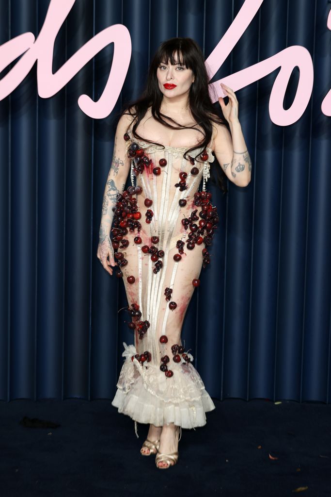 Dilara Findikoglu wears a sheer dress with black cherries dotted all over the bodice and skirt