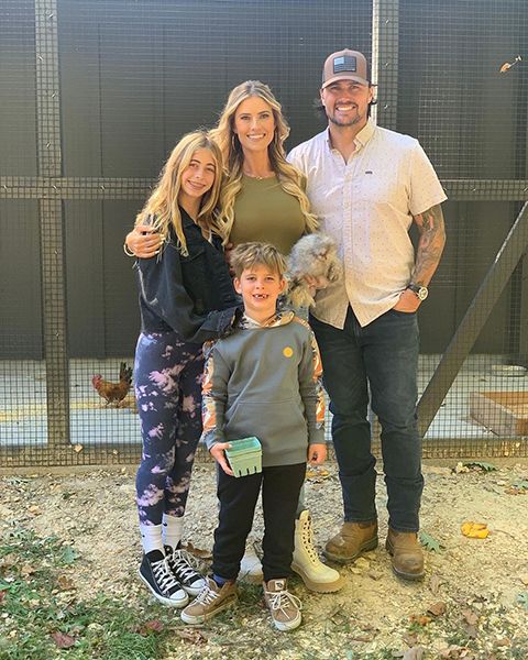 christina hall posing with family outside chicken coop
