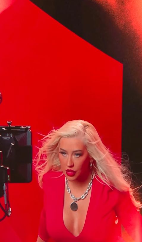 Christina Aguilera in red outfit posing in front of camera