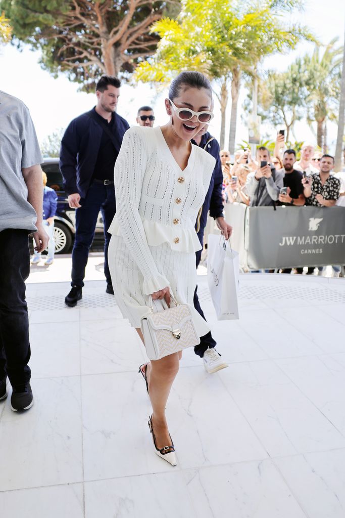  Selena Gomez is seen during the 77th Cannes Film Festival on May 17 in a white cardigan and matching skirt set