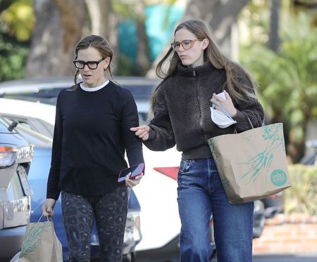 Violet Affleck in jeans and sweater and Jennifer Garner in leggings