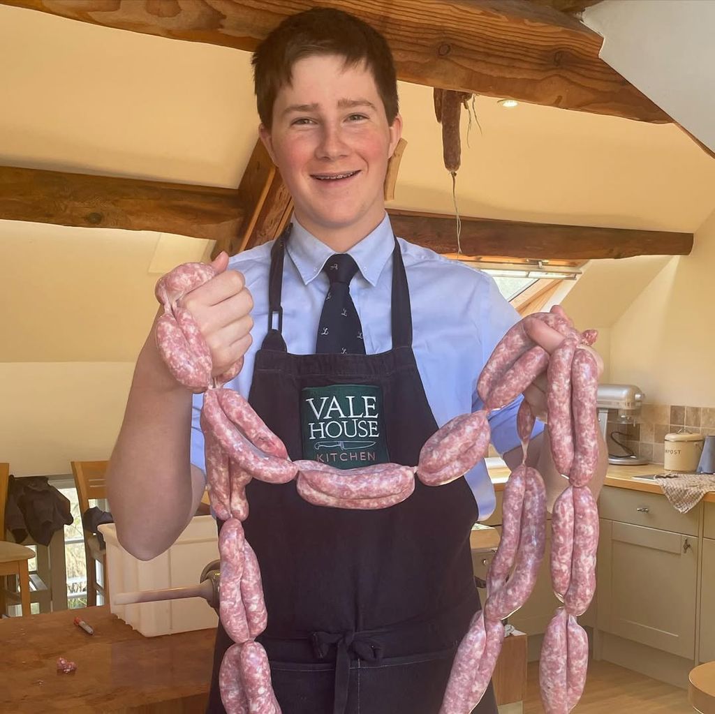 Bear Grylls' son holding up sausages