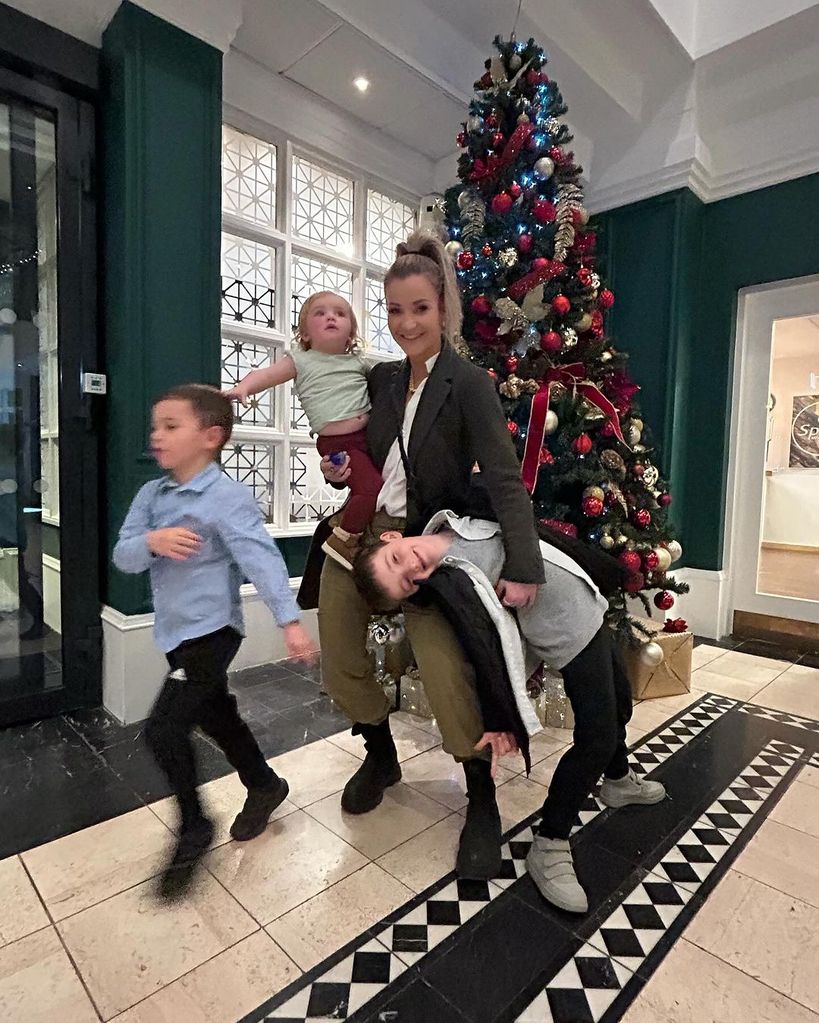 mother with three children and christmas tree 